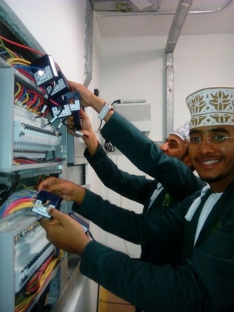 Higher College of Technology students installing CTs under Mike's supervision during the data acquisition system installation phase of the EcoHouse Design Competition